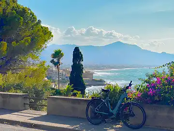 Ein Fahrrad steht an der Küstenstraße von Mongerbino mit Blick auf den Golf von Palermo.