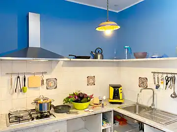 Die Küche der Casa Enza in der ein Nudelgericht mit viel Gemüse vorbereitet wird.