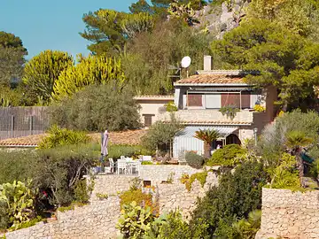 Ein Haus, umgeben von Bäumen und Sträuchern, in einer ruhigen, natürlichen Umgebung.