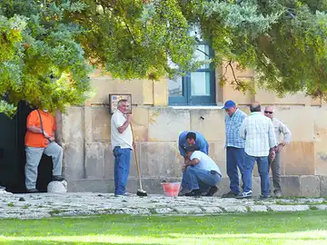 Eine Gruppe von Handwerkern arbeitet gemeinsam an einem Gebäude.