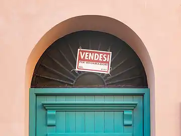 Vendesi-Schild auf der Tür einer Immobilie in Porticello.