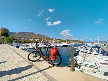 Ein Fahrrad steht auf einer Mole des Yachthafens von San Nicola l'Arena.