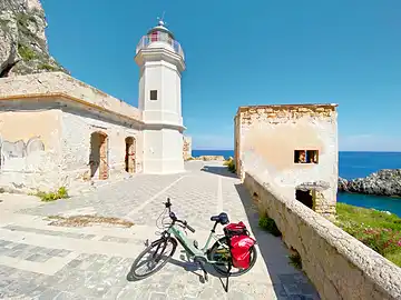 Ein Fahrrad steht vor dem Leuchtturm an der Spitze des Capo Zafferano.
