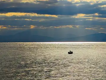 Un bateau de pêche solitaire au petit matin dans le golfe de Termini Imerese.