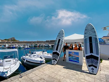 Stand des Bootsverleihs 'SicilyGoBoat' auf einem Pier im Hafen von Porticello.