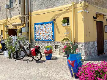Ein Mietfahrrad von Sicula Bike steht vor einer Pinwand mit Kontaktadressen.
